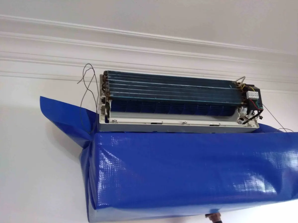 Evaporadora aberta com bolsa coletora azul durante a higienização