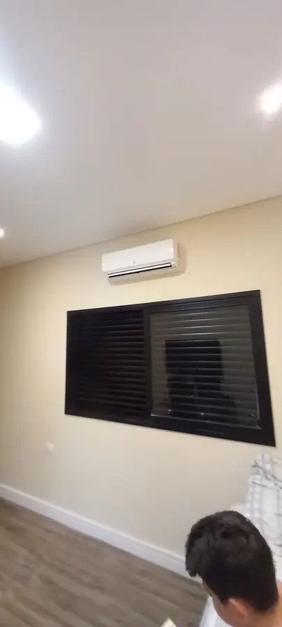 Split instalado acima de janela com persiana escura